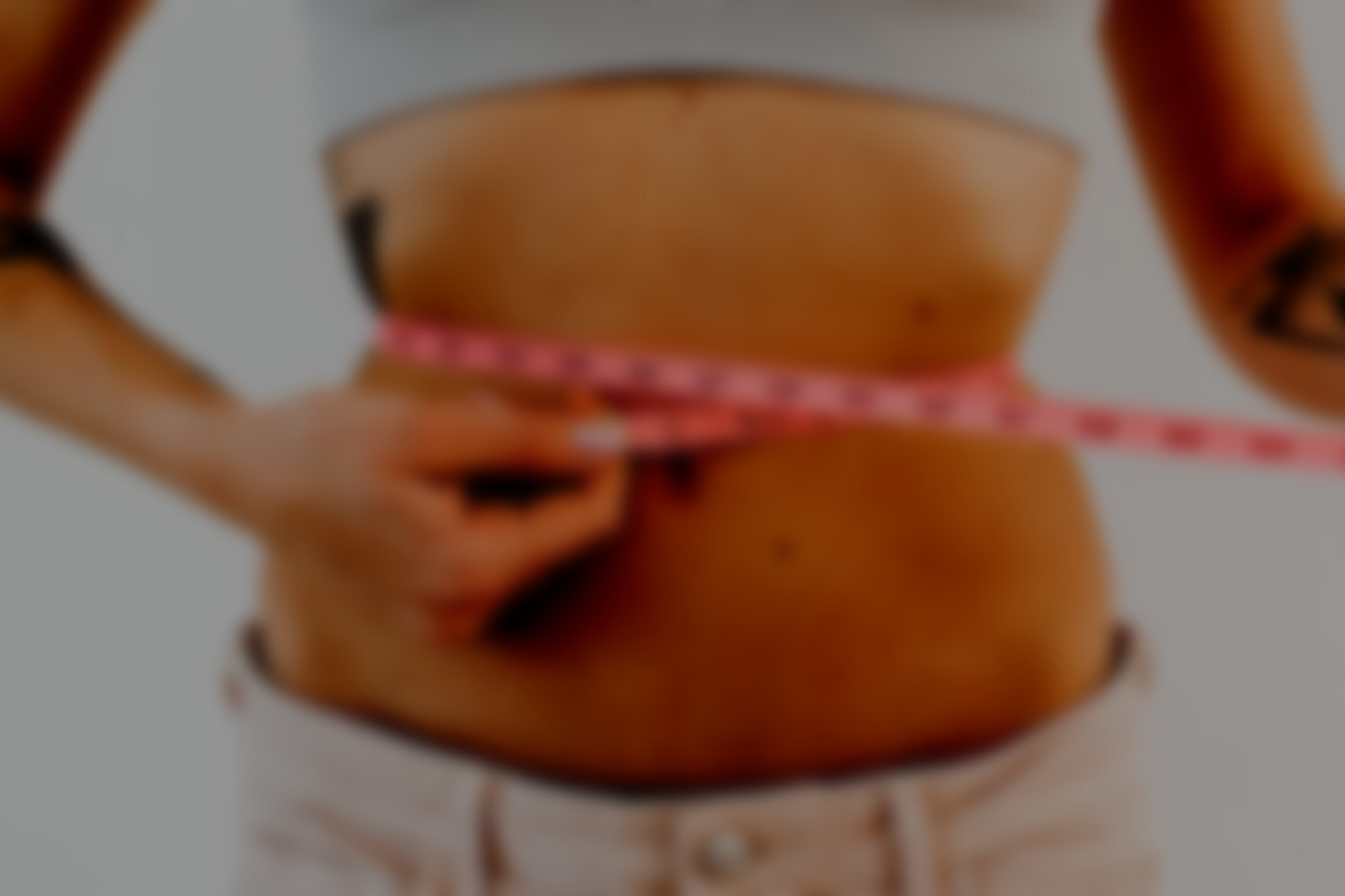 Woman Measuring Waistline With a Pink Tape Measure